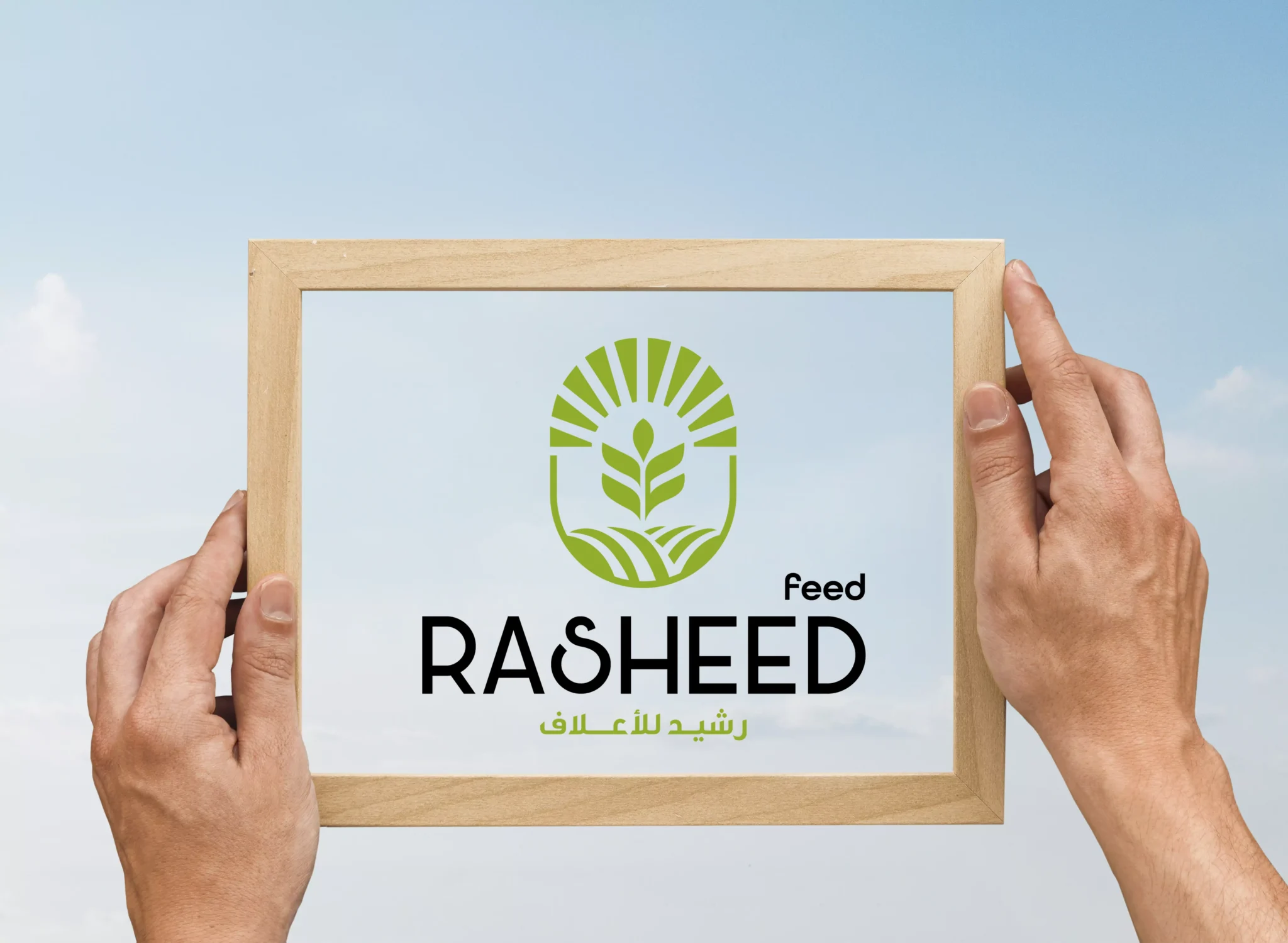 Hands holding a wooden frame with Rasheed a blue sky